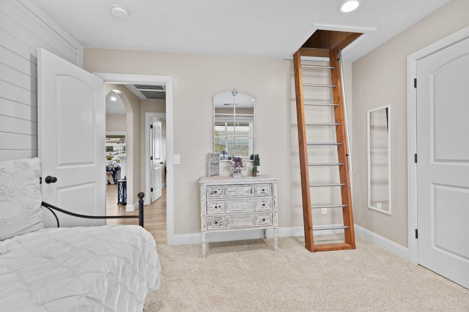 Bedroom featuring light colored carpet, recessed lighting, and arched walkways