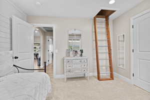 Bedroom featuring light colored carpet, recessed lighting, and arched walkways