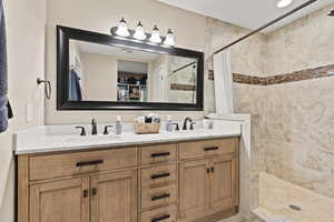 Bathroom featuring a walk in closet and tiled shower