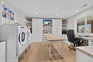 Laundry room featuring light wood finished floors, recessed lighting, washing machine and clothes dryer, and a desk