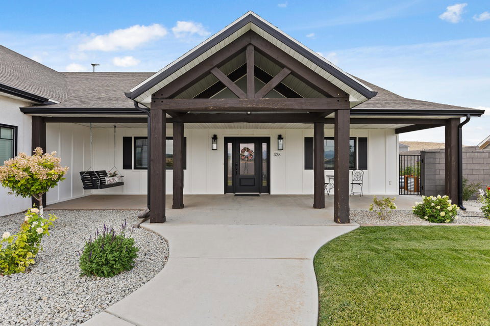 View of exterior entry with a porch and roof with shingles