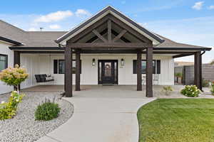 View of exterior entry with a porch and roof with shingles
