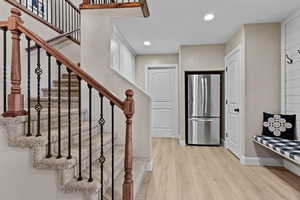 Entryway featuring light wood-style flooring, recessed lighting, and stairway