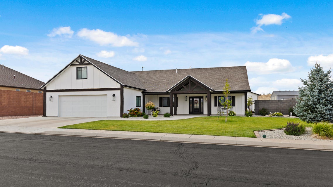 Modern farmhouse featuring covered porch, a garage, board and batten siding, concrete driveway, and roof with shingles
