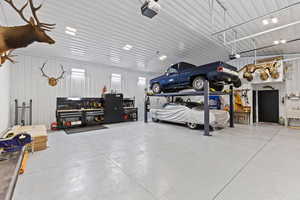Garage with metal wall, a workshop area, and a garage door opener