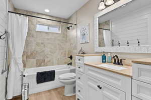 Bathroom with shower / bath combo with shower curtain, vanity, and light wood finished floors