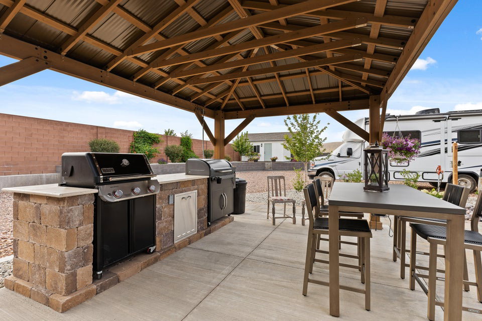 Fenced backyard featuring exterior kitchen and a patio