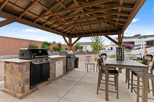 Fenced backyard featuring exterior kitchen and a patio
