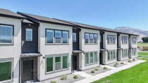 View of front of house with stucco siding, a standing seam roof, and a metal roof