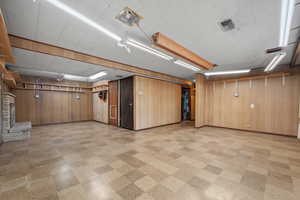Finished basement featuring light flooring and wood walls