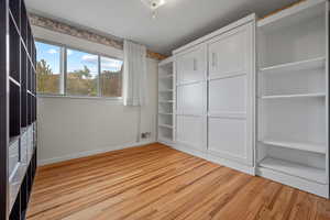 Unfurnished bedroom with light wood-style floors and baseboards