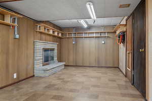 Basement featuring wooden walls and a fireplace