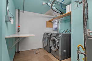 Laundry area featuring tile patterned floors and washing machine and clothes dryer