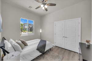 Bedroom with light wood-style flooring, a closet, and ceiling fan