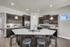 Kitchen with dark brown cabinetry, tasteful backsplash, stainless steel appliances, and recessed lighting