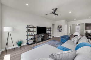 Living room featuring recessed lighting, light wood-type flooring, and a ceiling fan