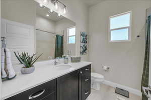 Bathroom featuring vanity, light tile patterned floors, and a shower with shower curtain