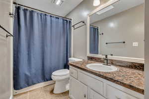 Bathroom with vanity, light tile patterned floors, and shower / bath combo