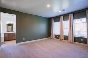 Unfurnished room with light colored carpet and recessed lighting