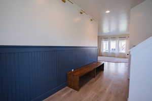 Hall featuring wainscoting, wood finished floors, and recessed lighting