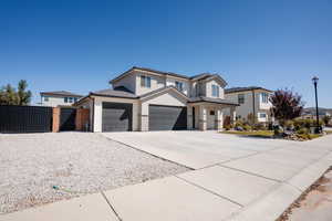 View of front of property with a gate, driveway, a tiled roof, stone siding, and stucco siding