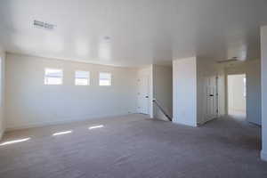 Carpeted spare room with baseboards and a textured ceiling