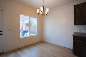 Unfurnished dining area with light wood-style floors and a chandelier