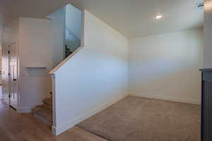 Basement featuring stairway, recessed lighting, and light wood-style flooring
