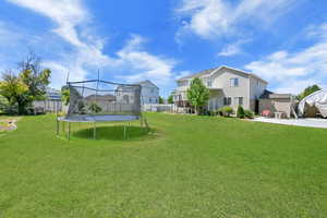View of yard featuring a trampoline and a patio area