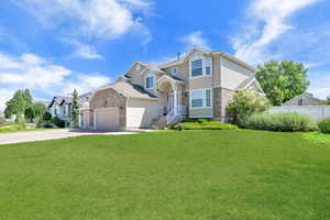 Traditional home featuring concrete driveway, brick siding, and stucco siding