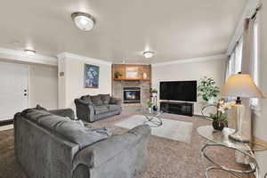 Carpeted living area featuring a brick fireplace, crown molding, and a textured ceiling