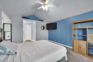 Bedroom with lofted ceiling, carpet floors, and a ceiling fan