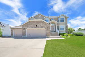 View of front of property featuring driveway, a garage, and brick siding