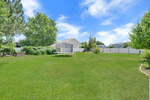 Fenced backyard featuring a trampoline