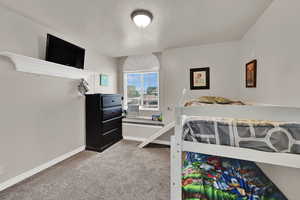 Bedroom with a textured ceiling and carpet flooring