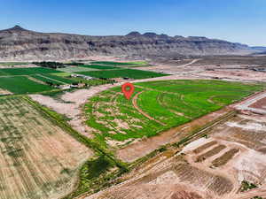 Aerial view of property and surrounding area featuring rural landscape, mountains, and large plots for crops