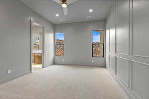 Unfurnished bedroom featuring recessed lighting, light colored carpet, ceiling fan, and ensuite bath