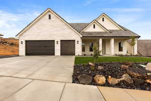 View of front of property featuring driveway, an attached garage, stucco siding, covered porch, and a front lawn