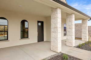 View of exterior entry featuring stucco siding and stone siding