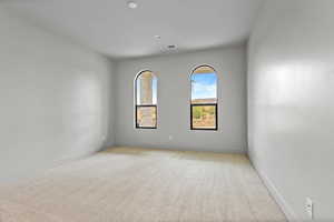Unfurnished room with baseboards and light colored carpet