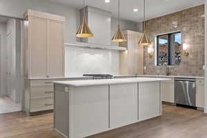 Kitchen featuring tasteful backsplash, dishwasher, pendant lighting, a kitchen island, and recessed lighting