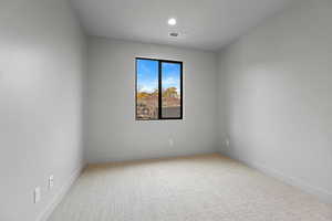 Empty room featuring light carpet and recessed lighting