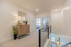 Corridor with carpet floors, an upstairs landing, and recessed lighting