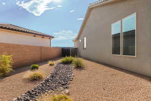 View of side of property featuring a fenced backyard and stucco siding