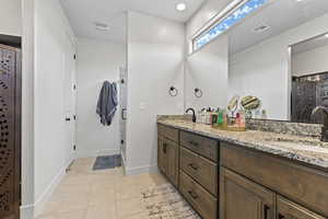 Bathroom featuring light tile patterned flooring, a shower stall, and recessed lighting