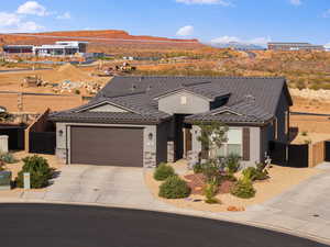View of front of home with a garage, concrete driveway, a mountain view, stone siding, and stucco siding