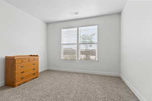 Bedroom with light carpet and baseboards