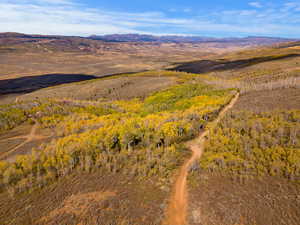 Aerial view of property and surrounding area with a mountain backdrop