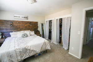 Carpeted bedroom featuring multiple closets