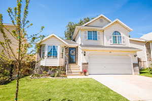View of front of home featuring a garage, concrete driveway, and roof with shingles